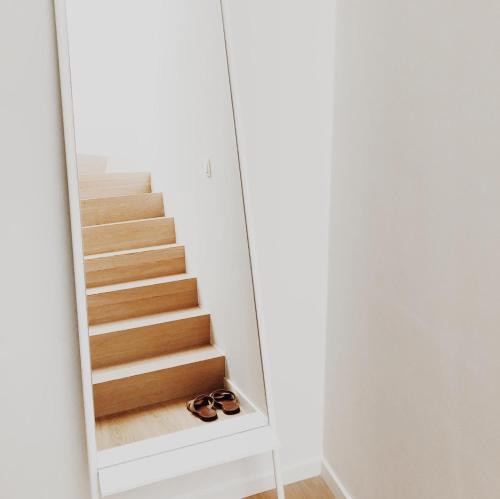 a mirror reflection of a staircase in a house at Penthouse La Naturale zeezicht in Zeebrugge