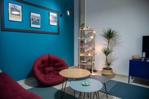 a living room with a red chair and a table at Apartments Steel Residence -Tesla Test Drive and 120 kW Supercharger in Timişoara