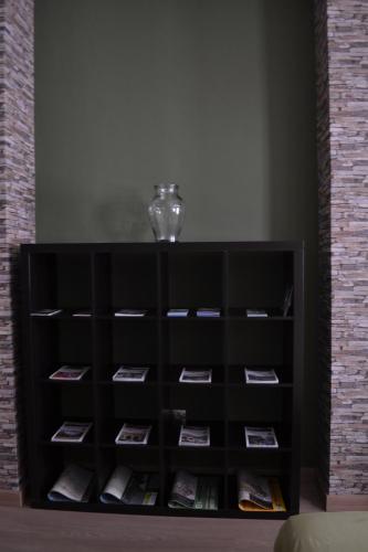 a book shelf with a vase on top of it at Apartamento Puerta del Pirineo in Sabiñánigo