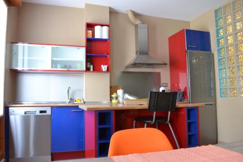 a kitchen with colorful cabinets and a counter at Apartamento Puerta del Pirineo in Sabiñánigo