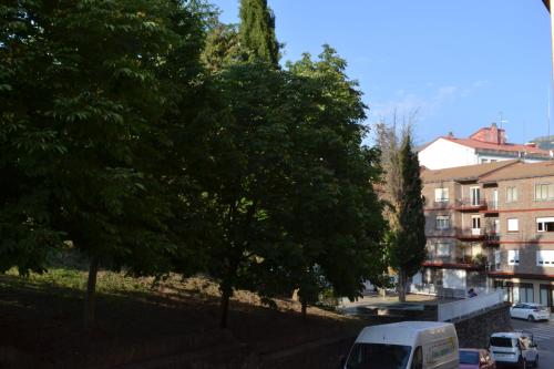 a white van parked next to some trees and buildings at Apartamento Puerta del Pirineo in Sabiñánigo