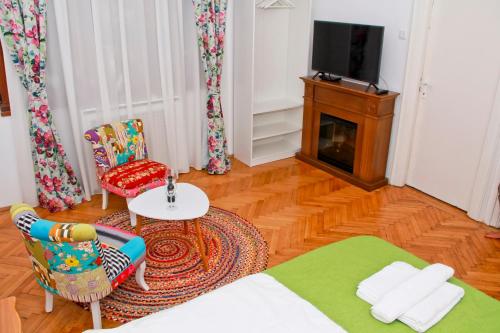 sala de estar con cama, sillas y TV en Bright Studio in the Heart of the City with Netflix, en Bucarest