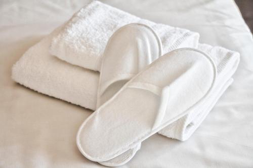 a pair of white towels on a bed at Charming Apartment near Athens Center and the Sea in Athens
