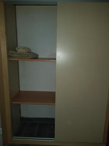 um armário com uma prateleira de madeira num quarto em cosy home em Rabat