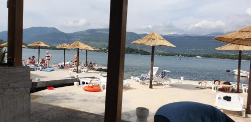 a view of a beach with chairs and umbrellas at Apartments Klakor PS in Tivat