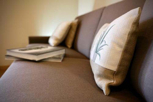a book on a couch with a pillow and a keyboard at LE SETTE VIE HOLIDAY HOMES in Monforte dʼAlba