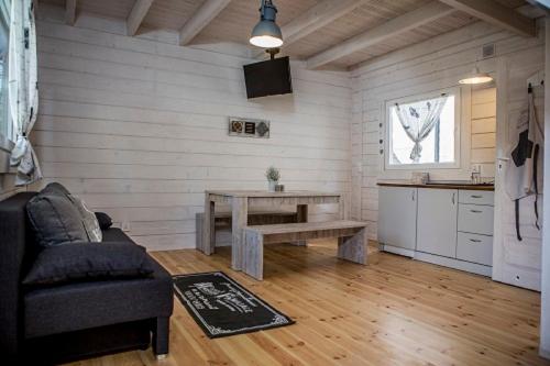 a living room with a table and a kitchen at biale domki in Pobierowo