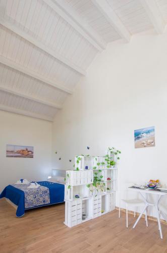 a white bedroom with a bed and a desk at Brezza di Stagnone in Birgi Vecchi