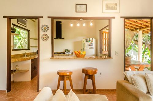 Eine Küche und ein Wohnzimmer mit einem Spiegel und zwei Hockern. in der Unterkunft Residencial Solares in Trancoso