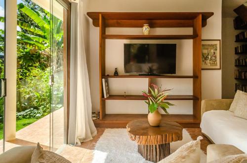 ein Wohnzimmer mit Fernseher und Tisch in der Unterkunft Residencial Solares in Trancoso