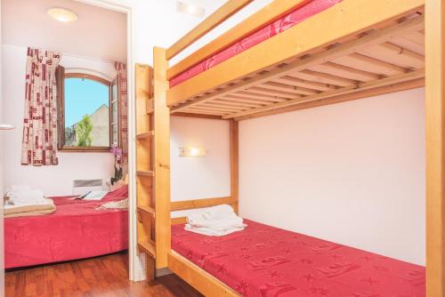 1 dormitorio con 2 literas y ventana en Résidence Vignec Village by Actisource, en Vignec