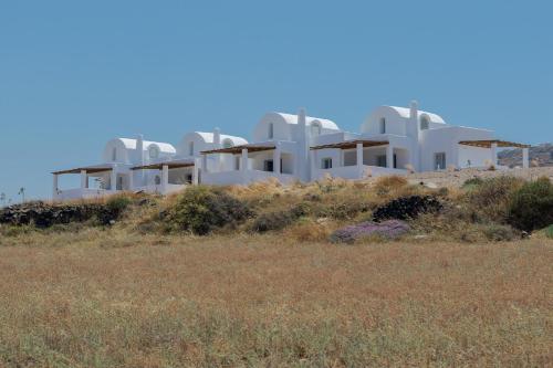 grupa białych domów na szczycie wzgórza w obiekcie Bianco Diverso Suites w Imerovíglion