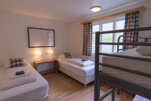
a hotel room with two beds and two lamps at Skyrhúsid Guest House in Hali
