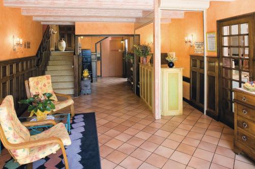 a lobby with chairs and a staircase in a building at Hotel De l'Europe in Meyrueis