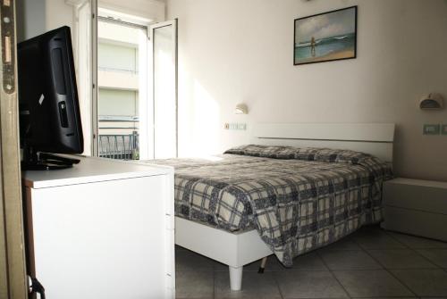 a bedroom with a bed and a flat screen tv at Residence Le Vele in Cattolica