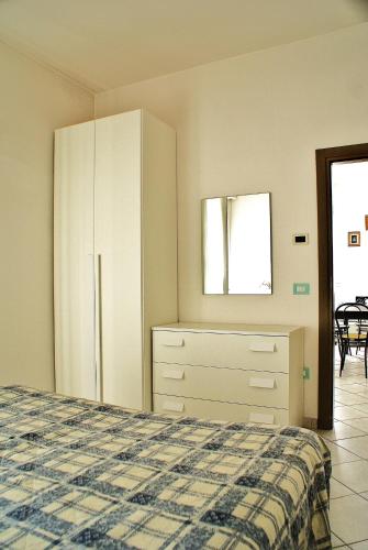 a bedroom with a bed and a dresser and a window at Residence Le Vele in Cattolica