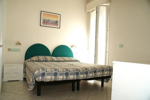a bedroom with a bed with a green headboard at Residence Le Vele in Cattolica