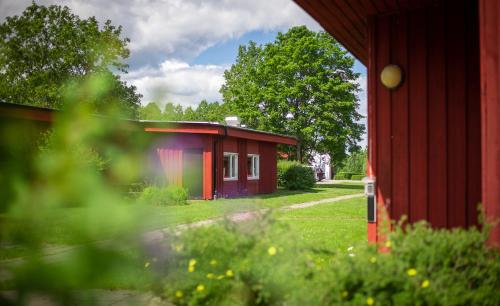 a small red building next to a red building at Karlskoga Folkhögskola Vandrarhem Udden in Karlskoga