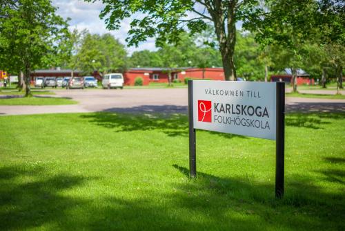 a sign in the grass next to a park at Karlskoga Folkhögskola Vandrarhem Udden in Karlskoga
