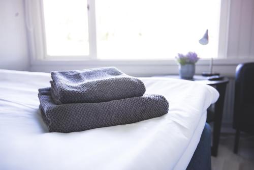 a stack of towels sitting on top of a bed at Karlskoga Folkhögskola Vandrarhem Udden in Karlskoga