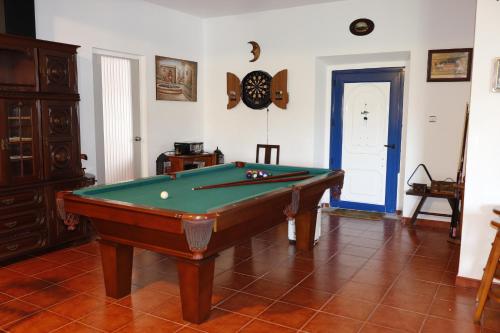 a room with a pool table and a clock on the wall at Monte do Parral in Santiago do Cacém