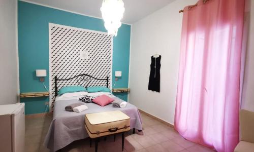 a bedroom with a bed with pink and blue walls at Alter Ego in Lascari