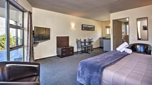 a hotel room with a bed and a balcony at Alexis Motel & Apartments in Queenstown