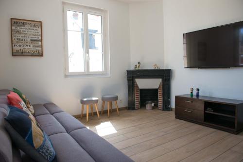 a living room with a couch and a flat screen tv at Villa Clarisse in Deauville