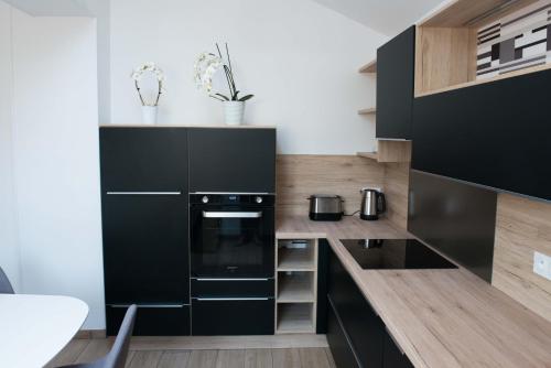 a kitchen with black appliances and wooden cabinets at Villa Clarisse in Deauville