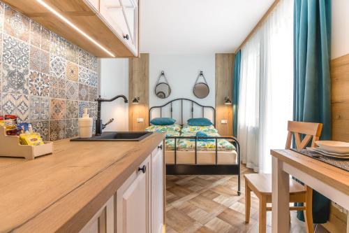 a kitchen with a sink and a bedroom with a bed at APARTAMENT MEWA in Sztutowo