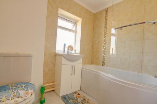een badkamer met een bad, een toilet en een wastafel bij Elvington House, entire house, kitchen, garden, parking, wifi in Kings Lynn