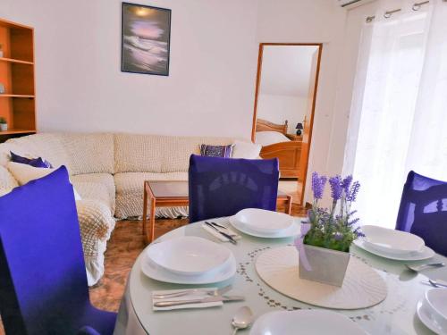 a living room with a table and blue chairs at Apartments Nevistic in Tribalj