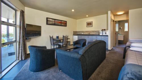 a living room with a couch and a table and chairs at Alexis Motel & Apartments in Queenstown