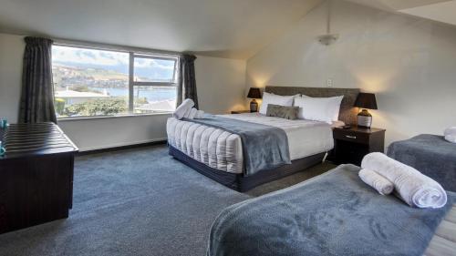 a bedroom with two beds and a large window at Alexis Motel & Apartments in Queenstown