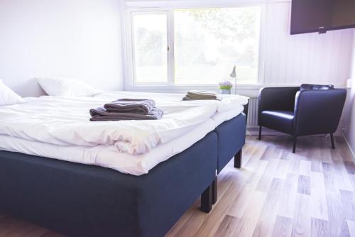 a bedroom with a bed and a chair and a window at Karlskoga Folkhögskola Vandrarhem Udden in Karlskoga