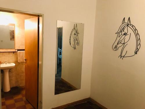 a bathroom with two drawings of horses on the wall at House in San Antonio de Areco