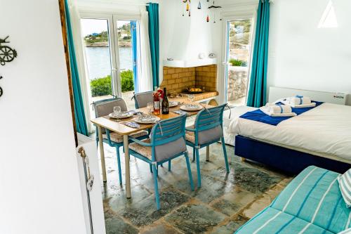 um quarto com uma mesa e cadeiras e uma cama em Seafront Villa Polyxene em Keratea