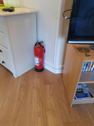 a red fire extinguisher sitting in a room at Valhalla bengtfors Private house in Bengtsfors