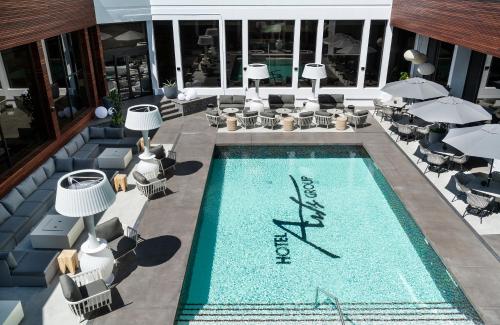 une piscine avec des chaises et un hôtel dans l'établissement Hotel Arts, à Calgary