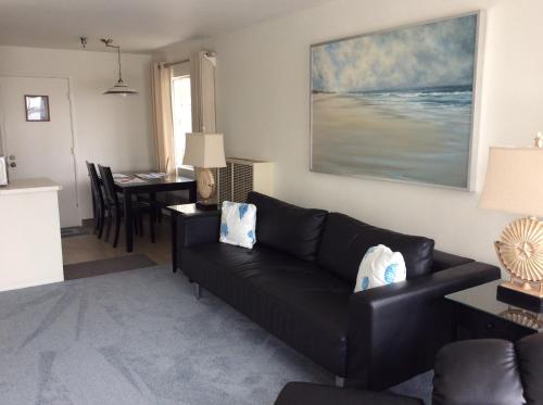 a living room with a black couch and a table at Gray's Inn & Gallery in Morro Bay