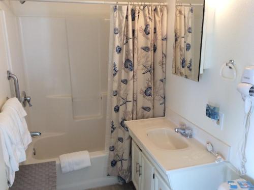 a bathroom with a tub and a sink and a shower at Gray's Inn & Gallery in Morro Bay