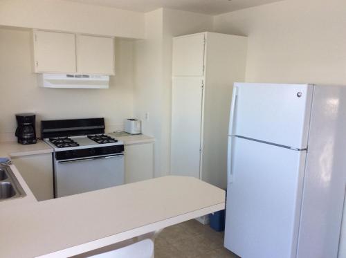 a kitchen with a white refrigerator and a stove at Gray's Inn & Gallery in Morro Bay