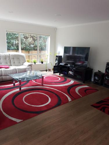a living room with a red and black rug at Sylvia Park House in Auckland