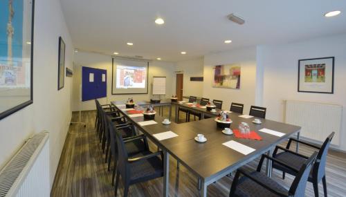 a conference room with a long table and chairs at HOTEL Am Spichernplatz in Düsseldorf