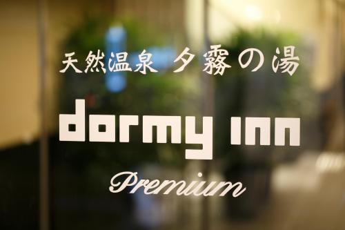 un cartel con escritura asiática en una ventana de cristal en Dormy Inn Premium Namba Natural Hot Spring, en Osaka