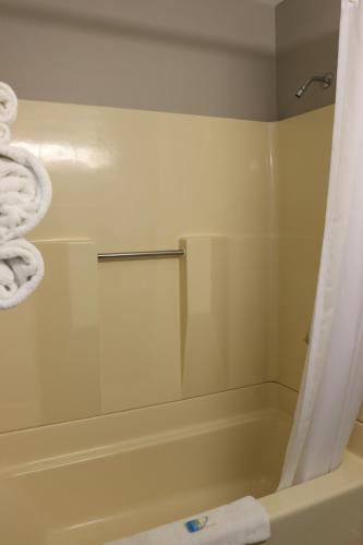 a bathroom with a tub and a shower with a shower curtain at Admiral Motel in Lake George