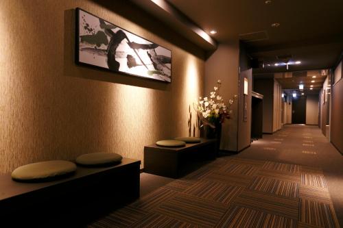 a hallway with two stools and a tv on the wall at Dormy Inn Premium Namba Natural Hot Spring in Osaka