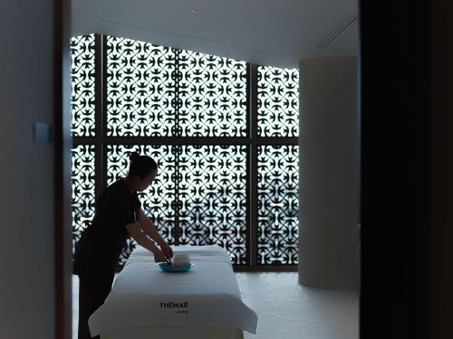 a man preparing a table in front of a window at Lake Shikotsu Tsuruga Bessou AO no ZA in Chitose