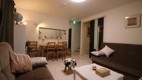 a living room with a couch and a table at COCO Shinjuku HOTEL in Tokyo