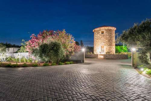 a brick driveway in front of a building at night at Apollon Windmill Boutique Hotel - Adults Only in Kos Town